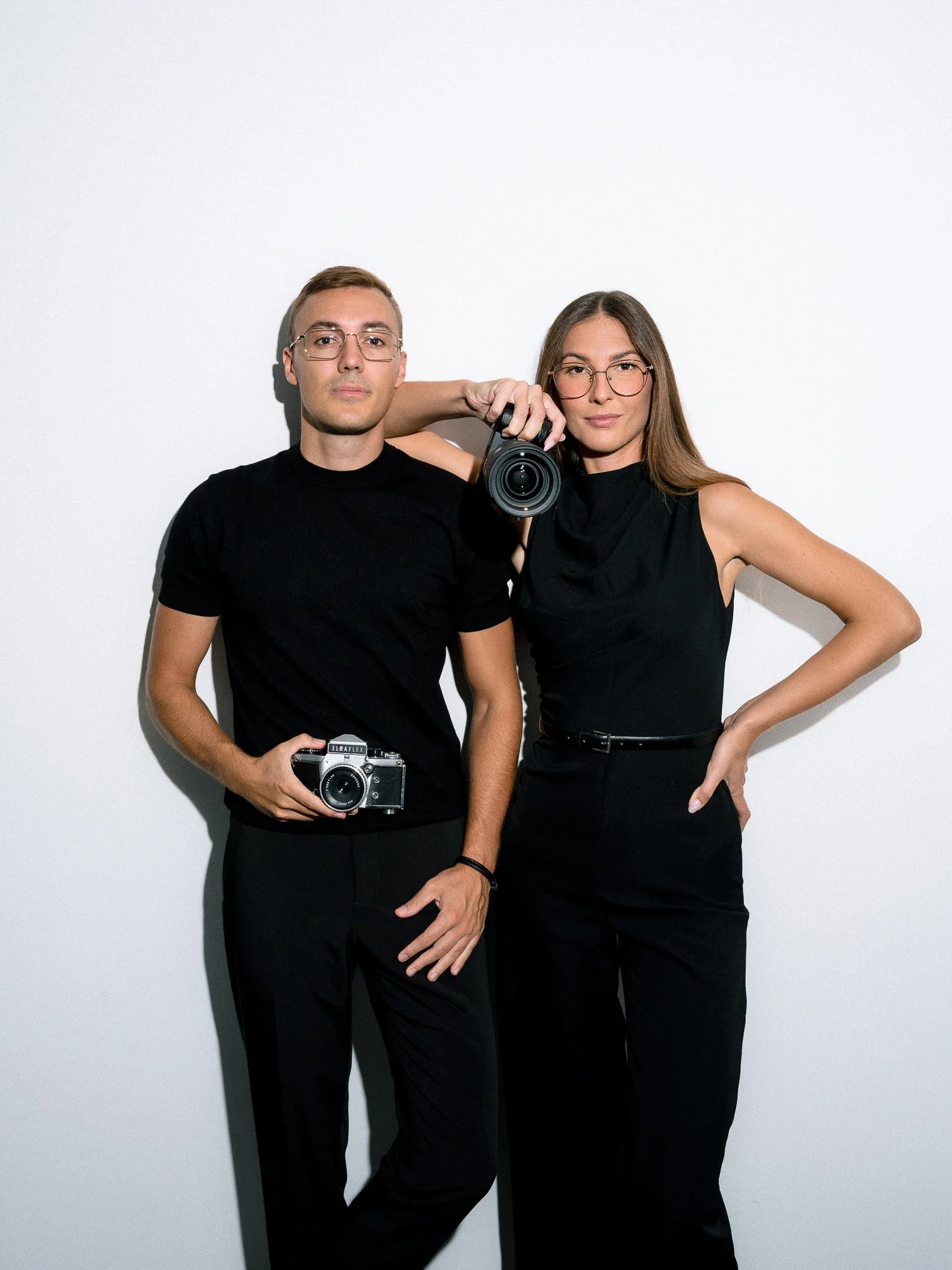 A married couple Ivan and Kim, photography and videography duo, standing with the cameras in their hands.