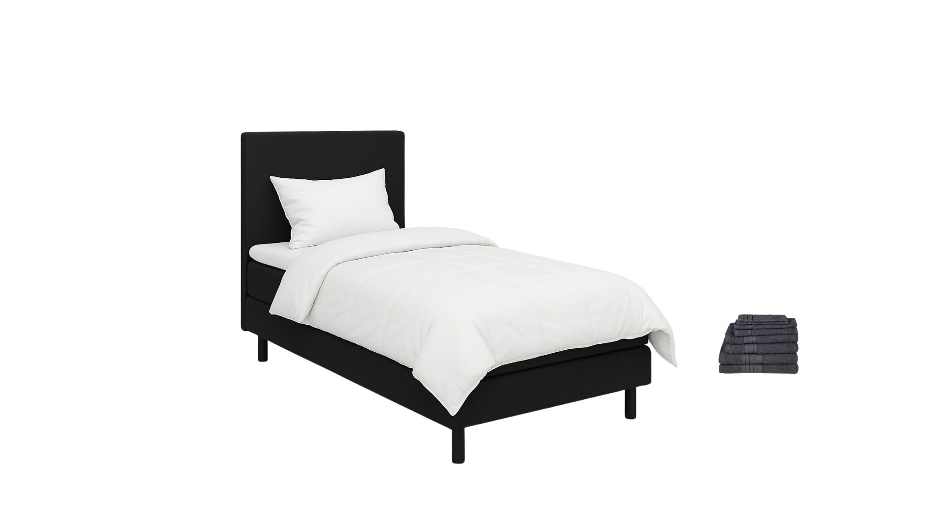 Black bed with white bedding, pillow, and blanket, with a stack of dark folded towels beside it.