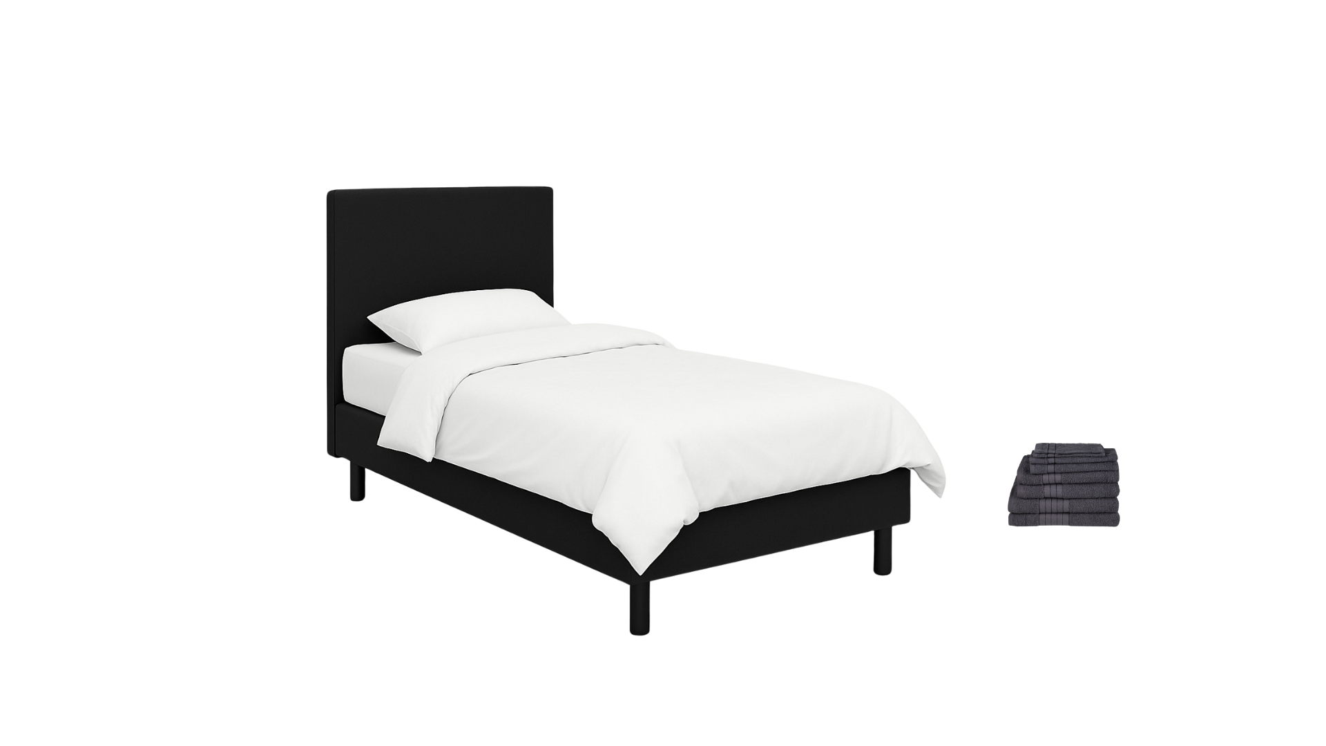 A neatly made bed with a black headboard, white bedding, and pillows, placed next to a small stack of dark gray towels.