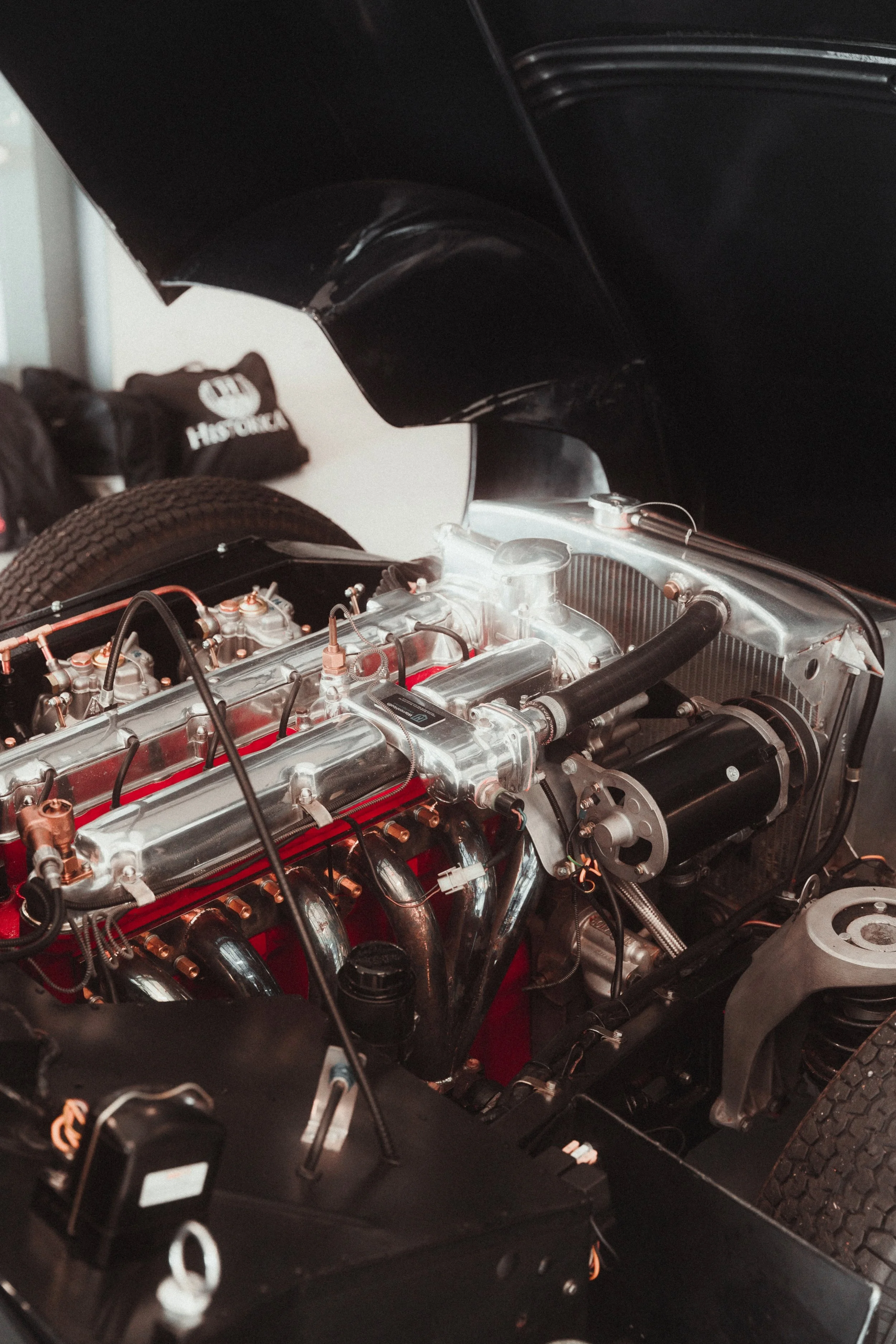 Close-up of a race car engine with polished metal components and black hoses.