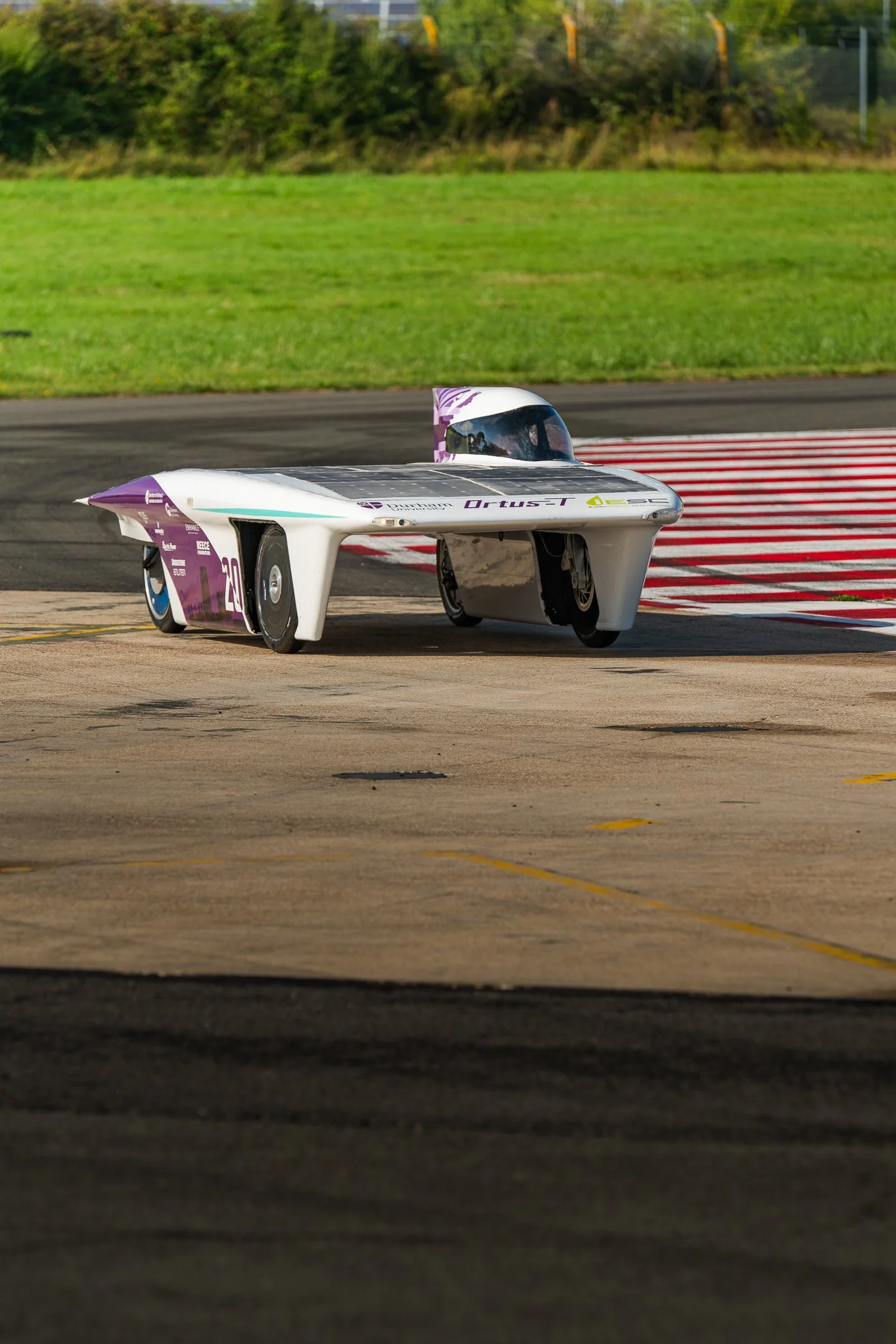 A futuristic, streamlined racing vehicle on a track, designed for speed, with a sleek body and enclosed cockpit.