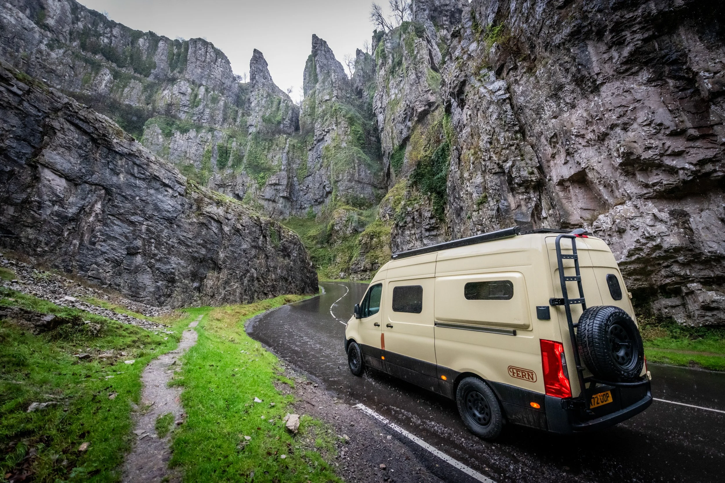 Fern campervan driving through Cheddar Gorge in Somerset on a wet day, showing its ability to explore remote landscapes while staying self-contained.