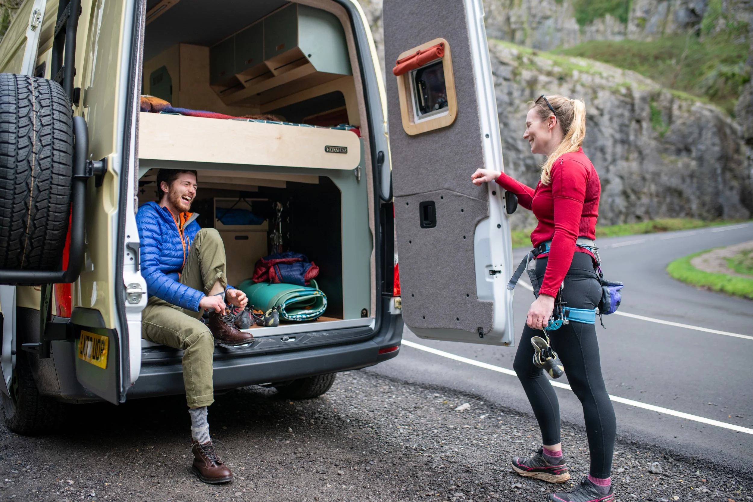 Two climbers getting ready at the rear of a Fern campervan, showing the spacious and adaptable garage storage for outdoor gear and adventure travel.