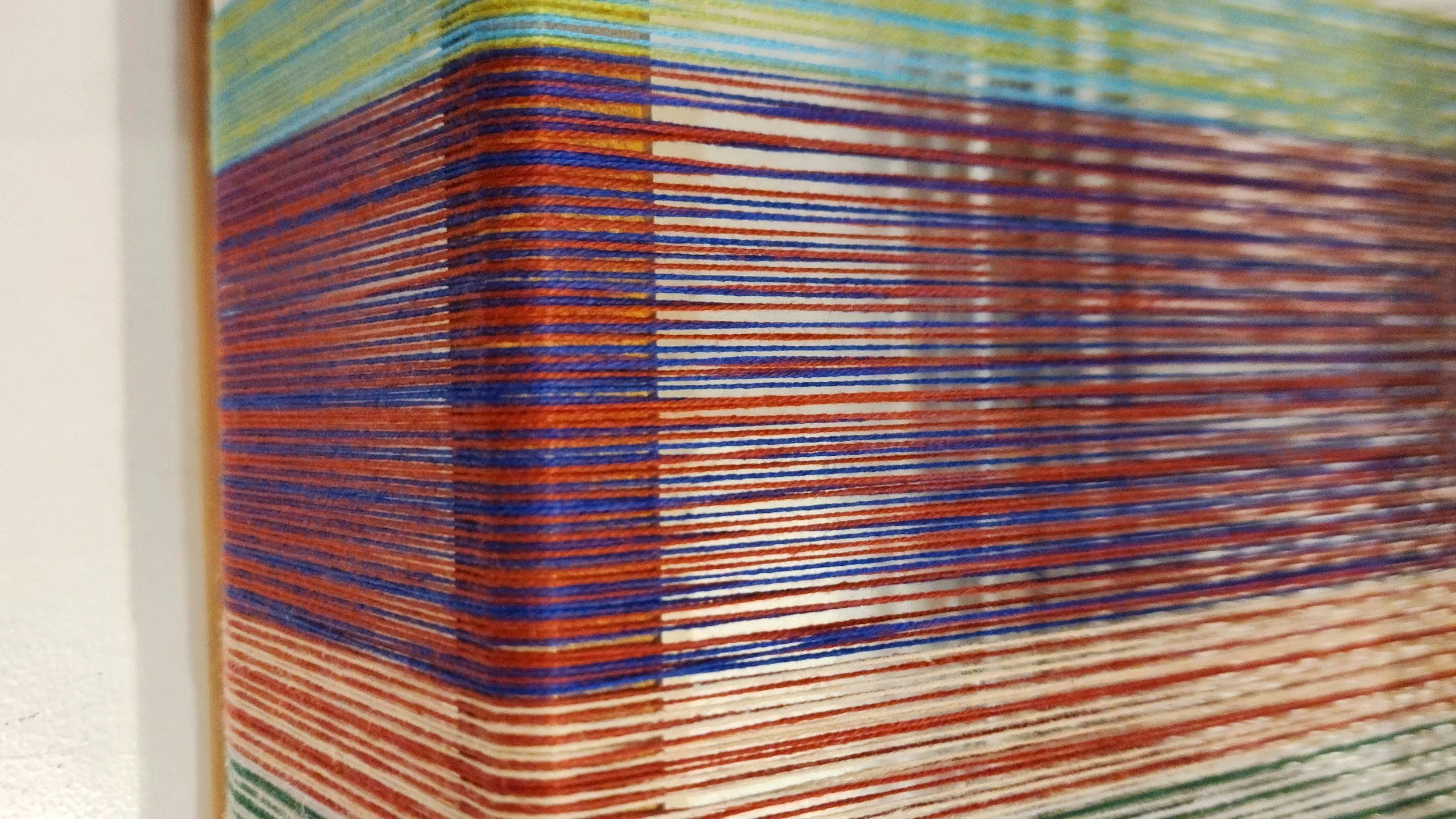 Close-up of a colorful stack of books or magazines with vibrant lines and patterns on the cover.
