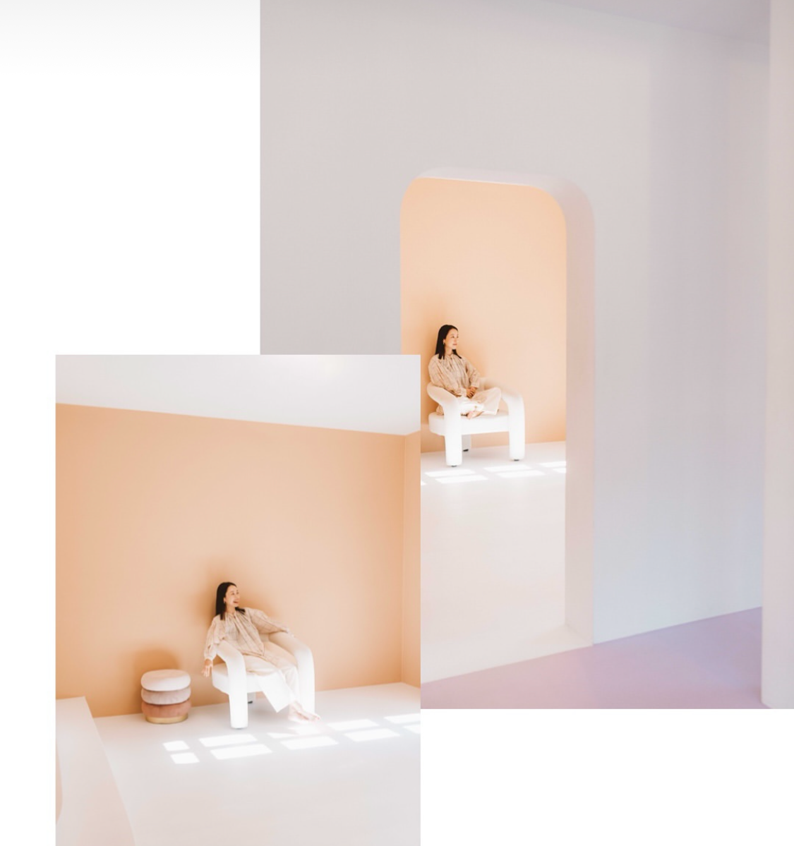 A woman sitting on a white chair with a rounded backrest in a minimalist room with peach and white walls, reading a book. The room has simple, modern decor with soft lighting.