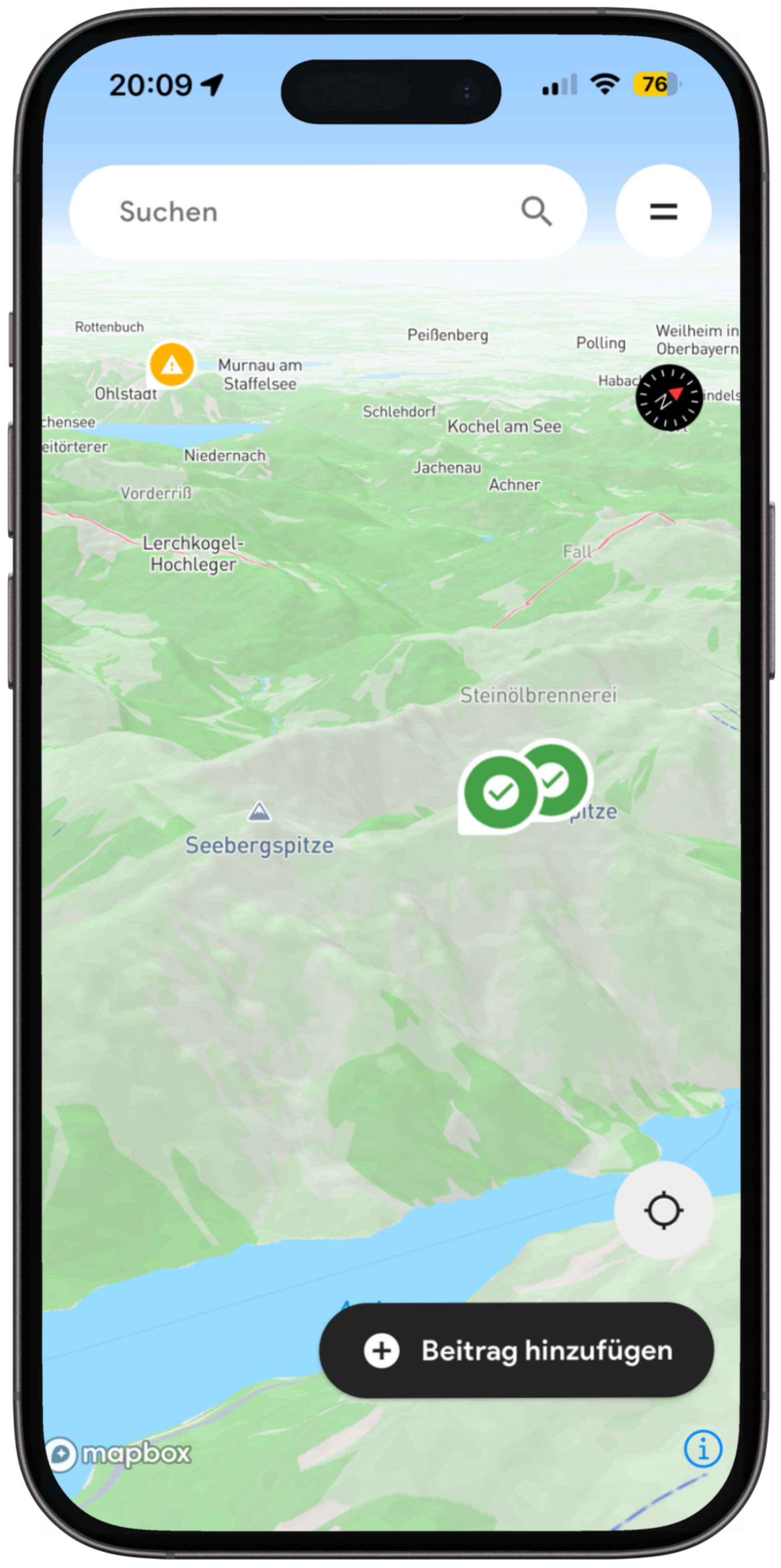 Digitale Karte mit topografischen Markierungen, grünen Bergen, Seen und Wegbeschreibungen, sowie einem Warnsymbol in Orange und einem Kompass in Schwarz. Es zeigt eine App mit Suchfunktion und Option zur Beitrags-Hinzufügung.