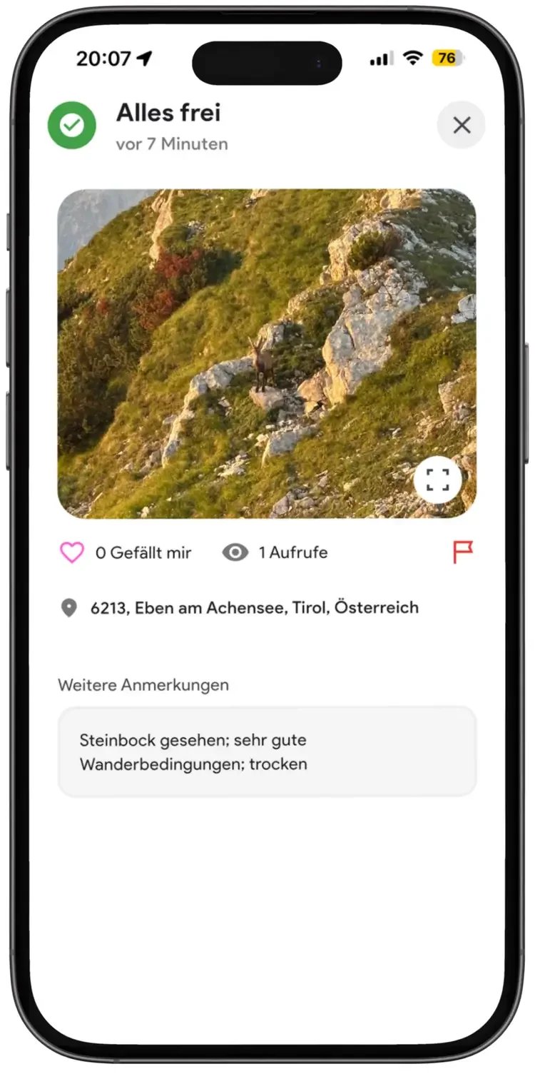 Ein Handybildschirm zeigt eine Wandertour am Achensee in Tirol, Österreich, mit einem See und Bergen im Hintergrund. Es gibt eine Bewertung mit dem Kommentar, dass der Steinbock gesehen wurde, mit guten Wanderbedingungen bei trockenem Wetter.