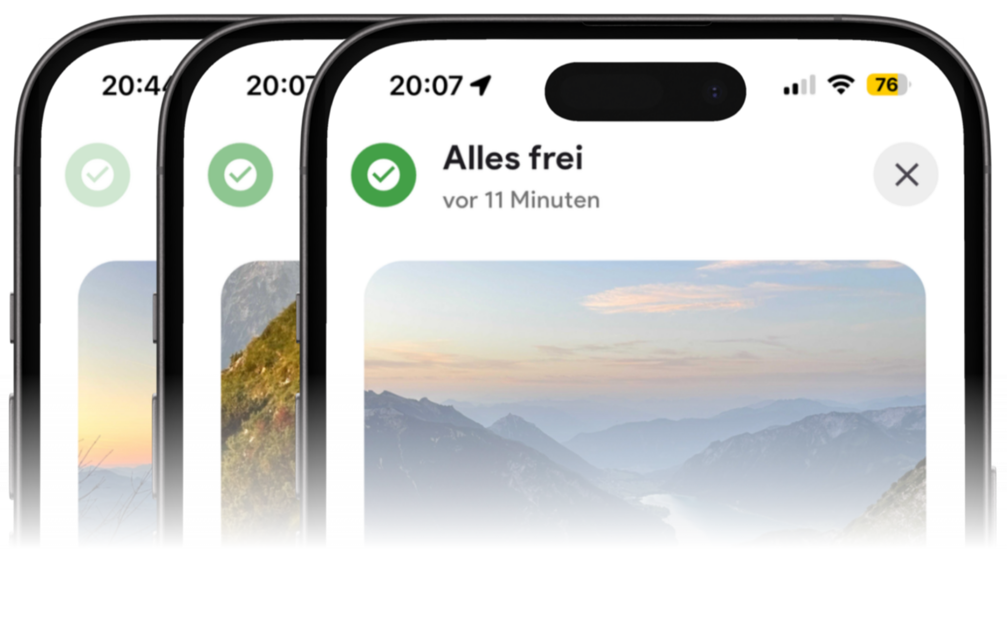 Screenshot eines Mobiltelefons mit einer App, die den Status 'Alles frei' anzeigt, mit einem Hintergrundbild von Bergen und Himmel bei Sonnenaufgang oder Sonnenuntergang.