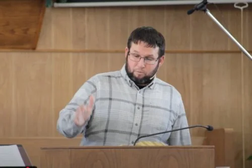 Man playing the marimba in a wooden room.
