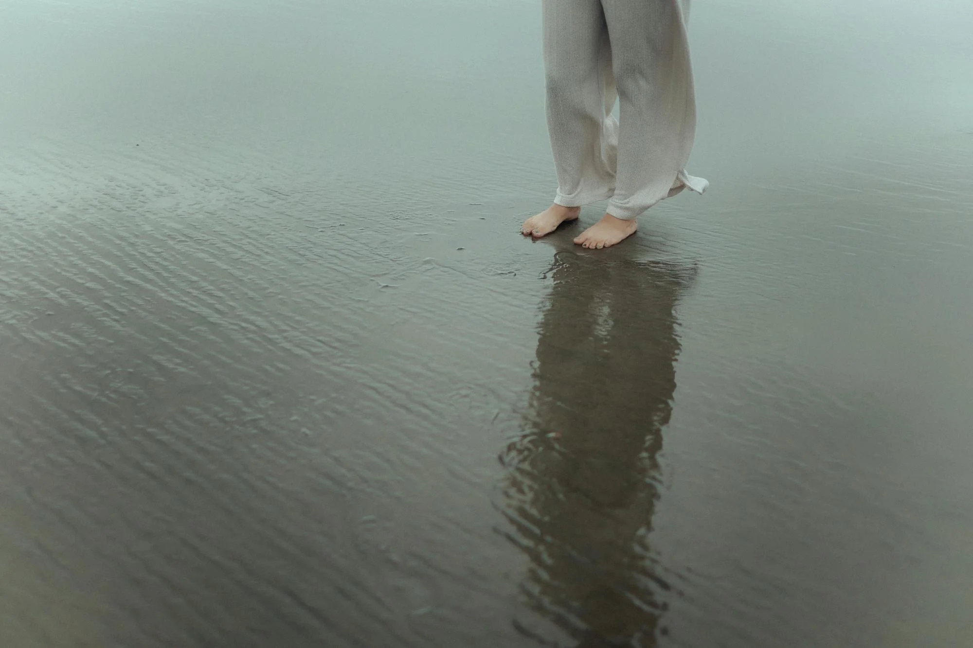 Legs of Woman Standing on Shallow Water