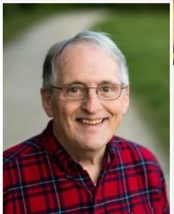 Portrait of an elderly man with glasses, white hair, wearing a red plaid shirt, smiling outdoors with green background