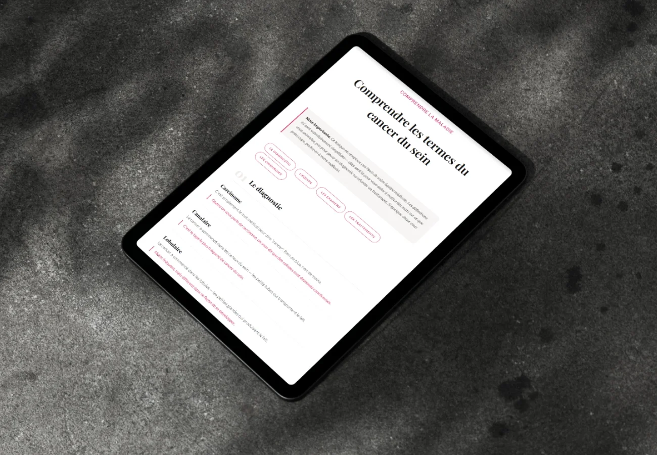 Un tablet affichant une page web sur la compréhension du cancer du sein, posé sur une surface sombre.