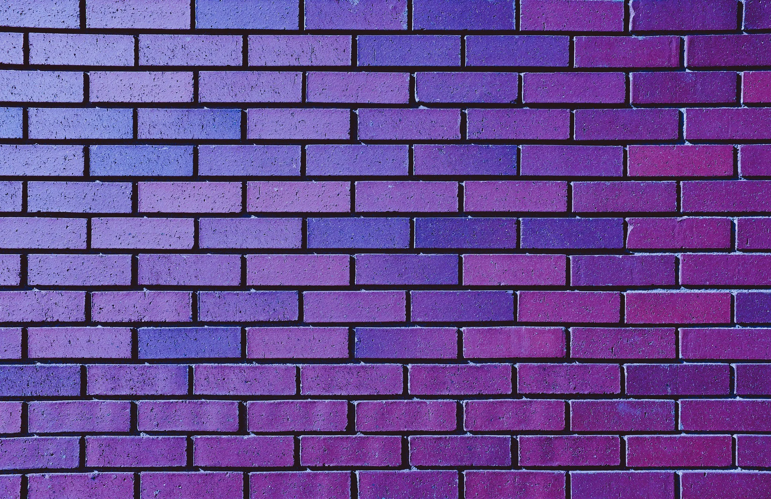 Muret en briques peint en niveaux de violet et de bleu