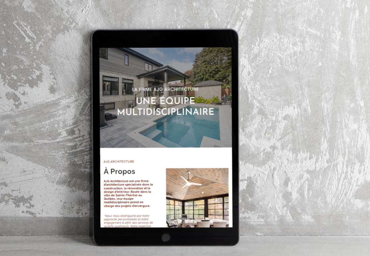 Une tablette affichant un site web d'architecture avec une maison moderne et une piscine à l'extérieur, posé contre un mur en béton.
