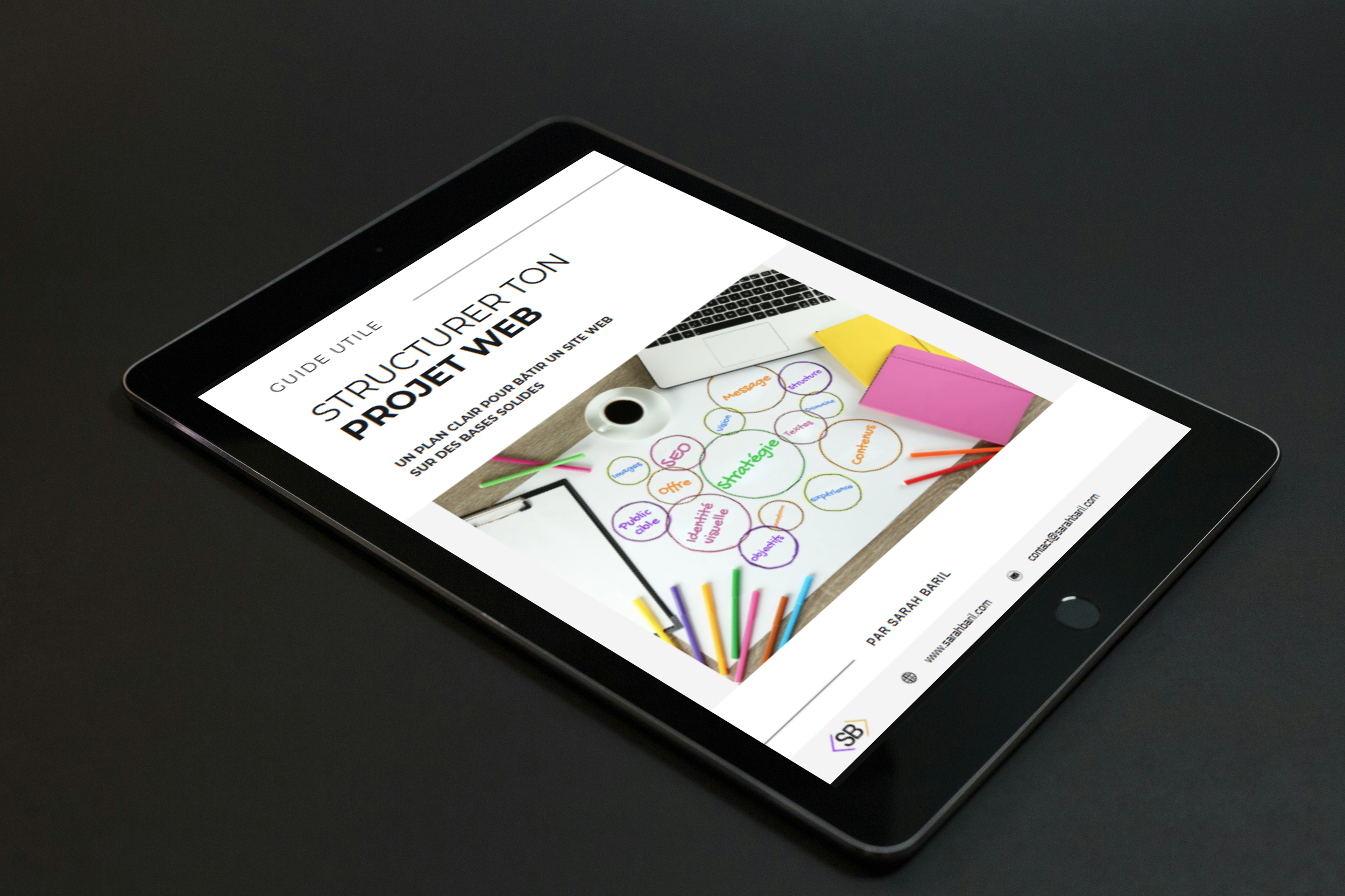 Guide utile pour construire un site web, illustré par un tableau avec des notes colorées, un ordinateur portable et des papiers de différentes couleurs.