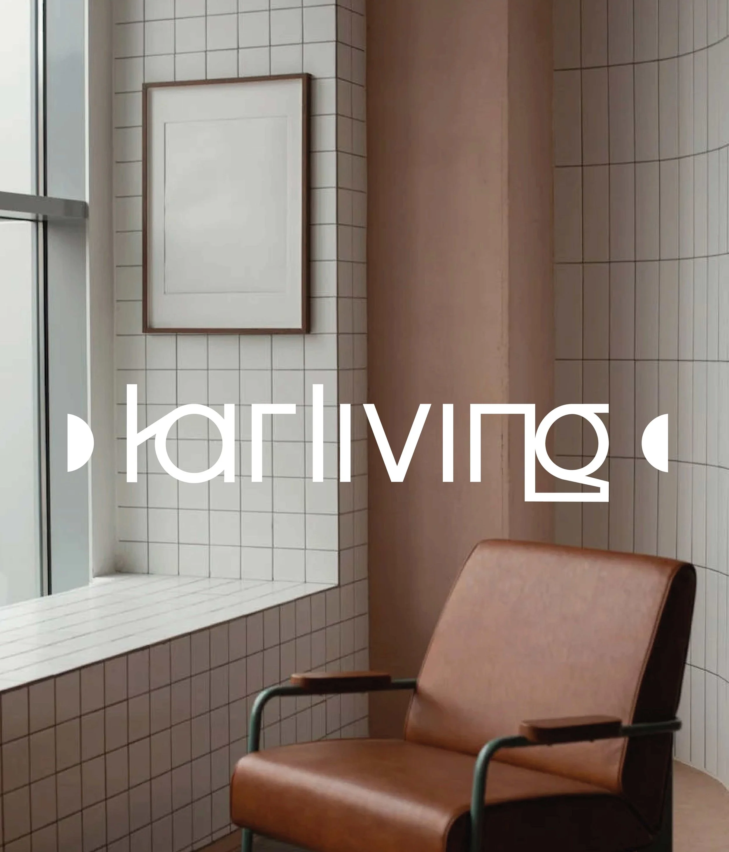 Logo typographique d'un entreprise d'architecture d'intérieur. Avec un fond photo représentant une pièce avec une chaise en cuir marron clair, des murs en carrelage blanc et une fenêtre. Il y a aussi un cadre accroché au mur et un mur peint en beige.