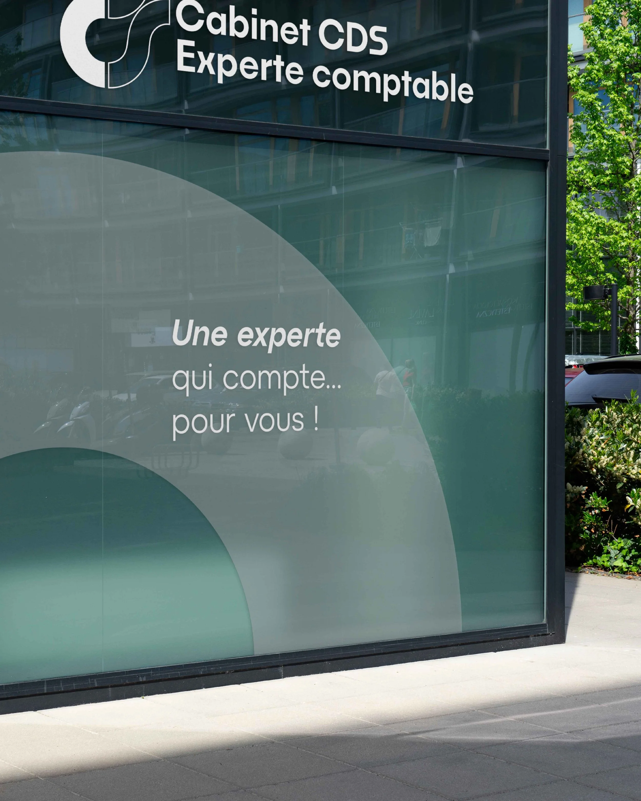 Une vitrine de cabinet d'expertise comptable avec le texte 'Cabinet CDS, Experte comptable' en haut, et 'Une experte qui compte... pour vous!' en dessous dans la vitre.
