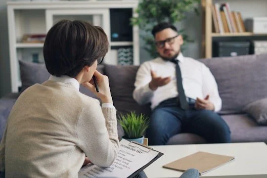 a-man-and-a-woman-sitting-on-a-couch-in-a-living-room