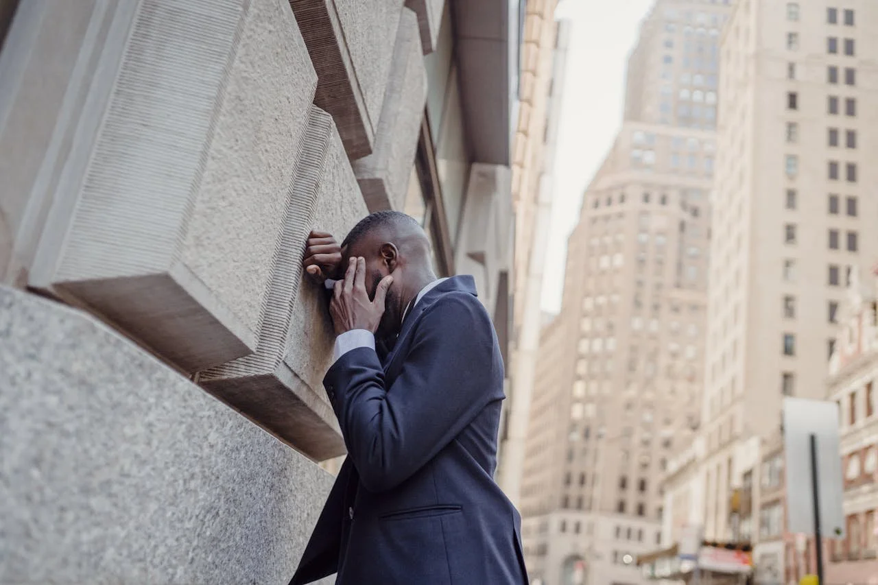 man-in-suit-standing-by-wall-in-city