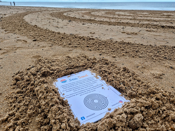 Labyrinth pattern in sand with instructions sheet on walking the maze