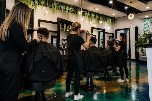 Hair salon with stylists cutting and styling clients' hair.