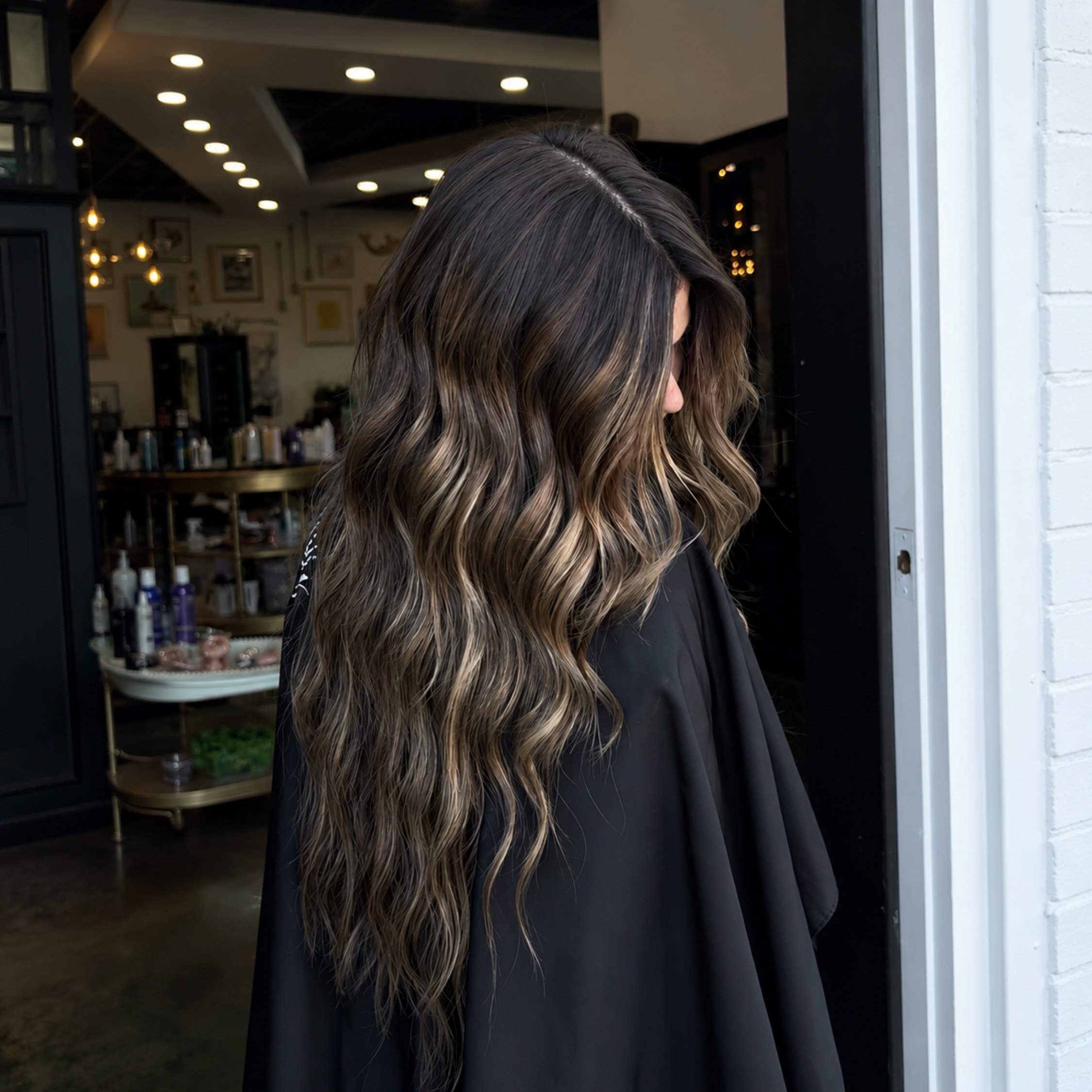 Long wavy brunette balayage with dimensional caramel highlights created at Studio 285