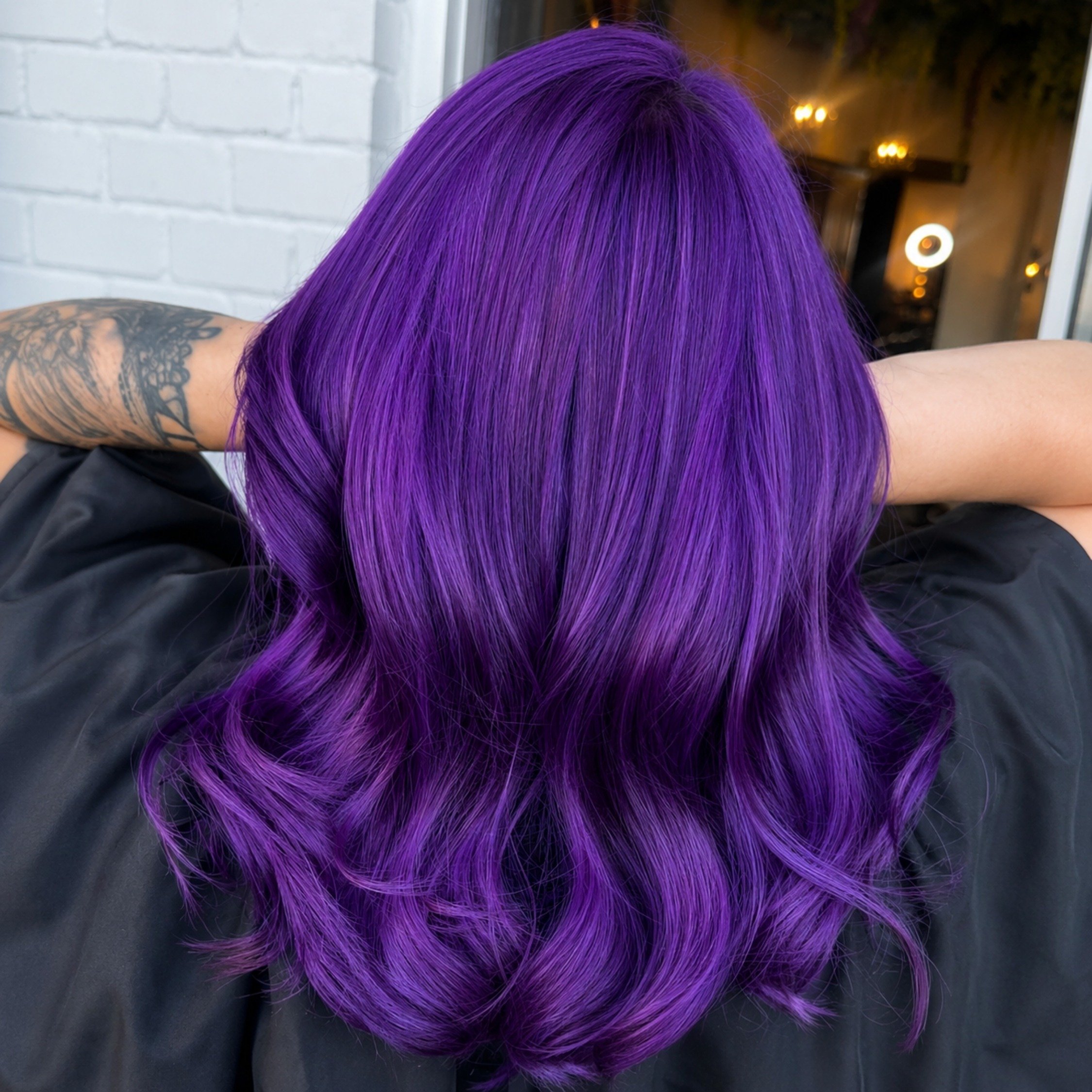 Vibrant purple shoulder-length hair with smooth texture and curled ends at Studio 285 salon