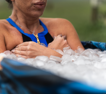 Person immersed in ice bath, arms crossed over chest