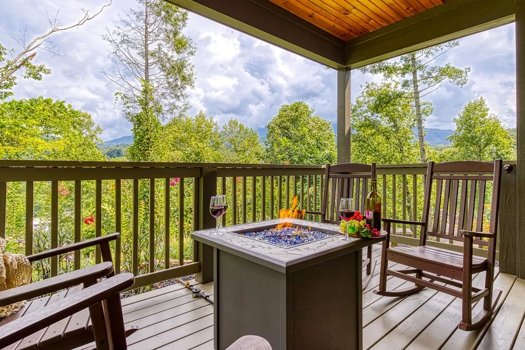 Living Color Cabin covered back porch with fire pit, rocking chairs, and happy hour wines.