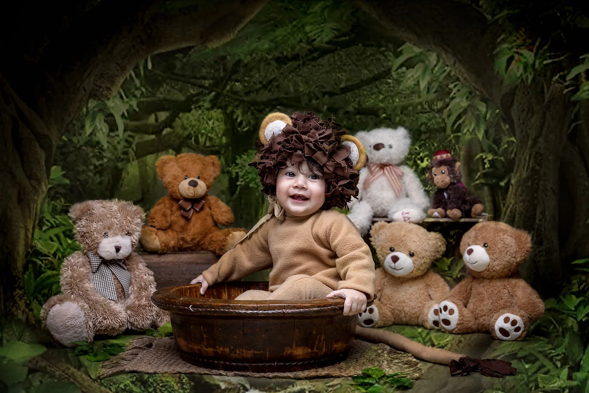 A young child dressed as a lion, with a mane and bear ears, sitting in a wooden basin inside a forest-like setting, surrounded by teddy bears and stuffed animals of various sizes and colors.