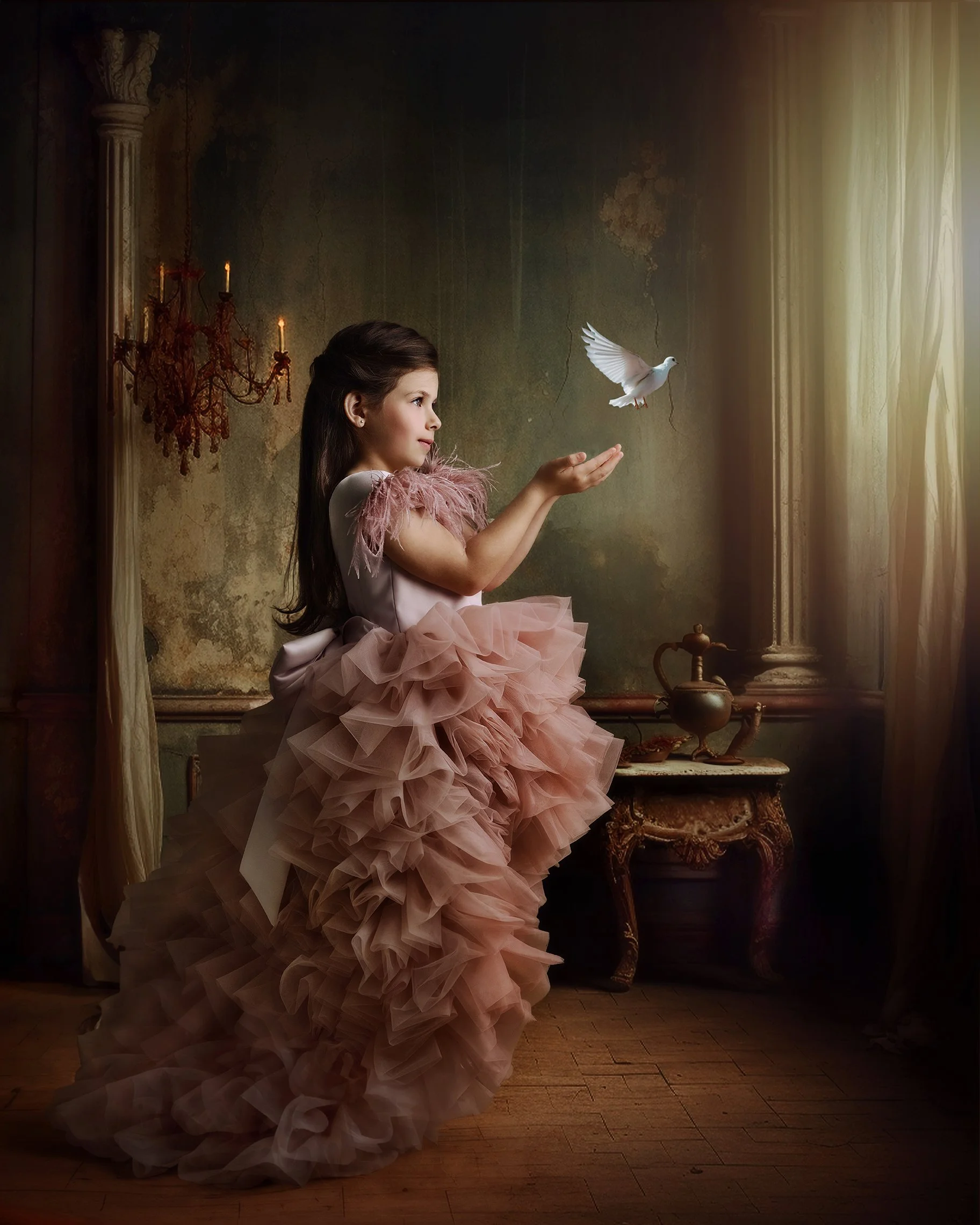 A young girl in a pink, ruffled dress standing in a vintage-style room, holding out her hand as a white dove flies toward her.