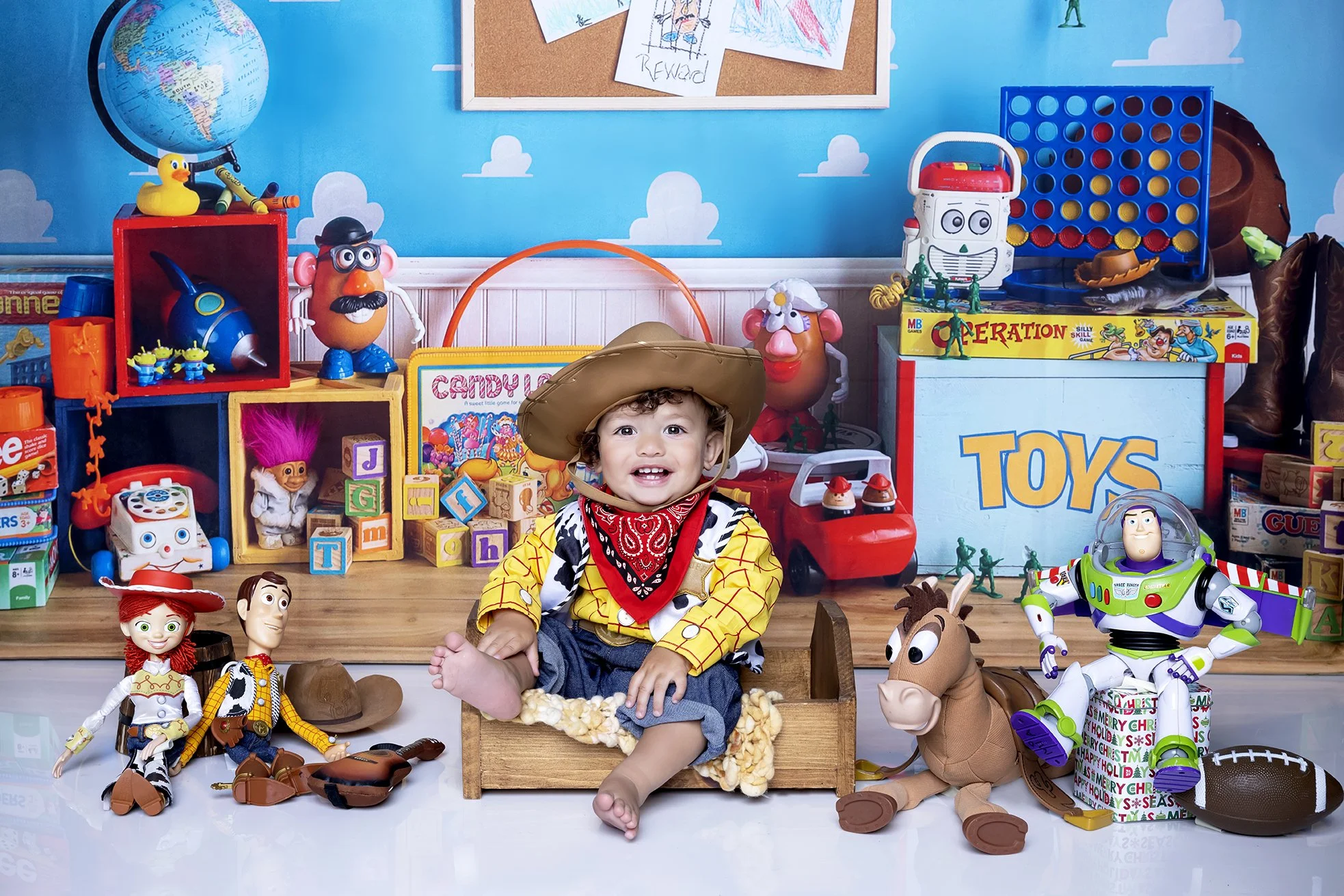 A young child dressed as a cowboy surrounded by toys from various movies, including Buzz Lightyear from Toy Story, Woody from Toy Story, and a plush horse, with a colorful background of toy storage and decorations.