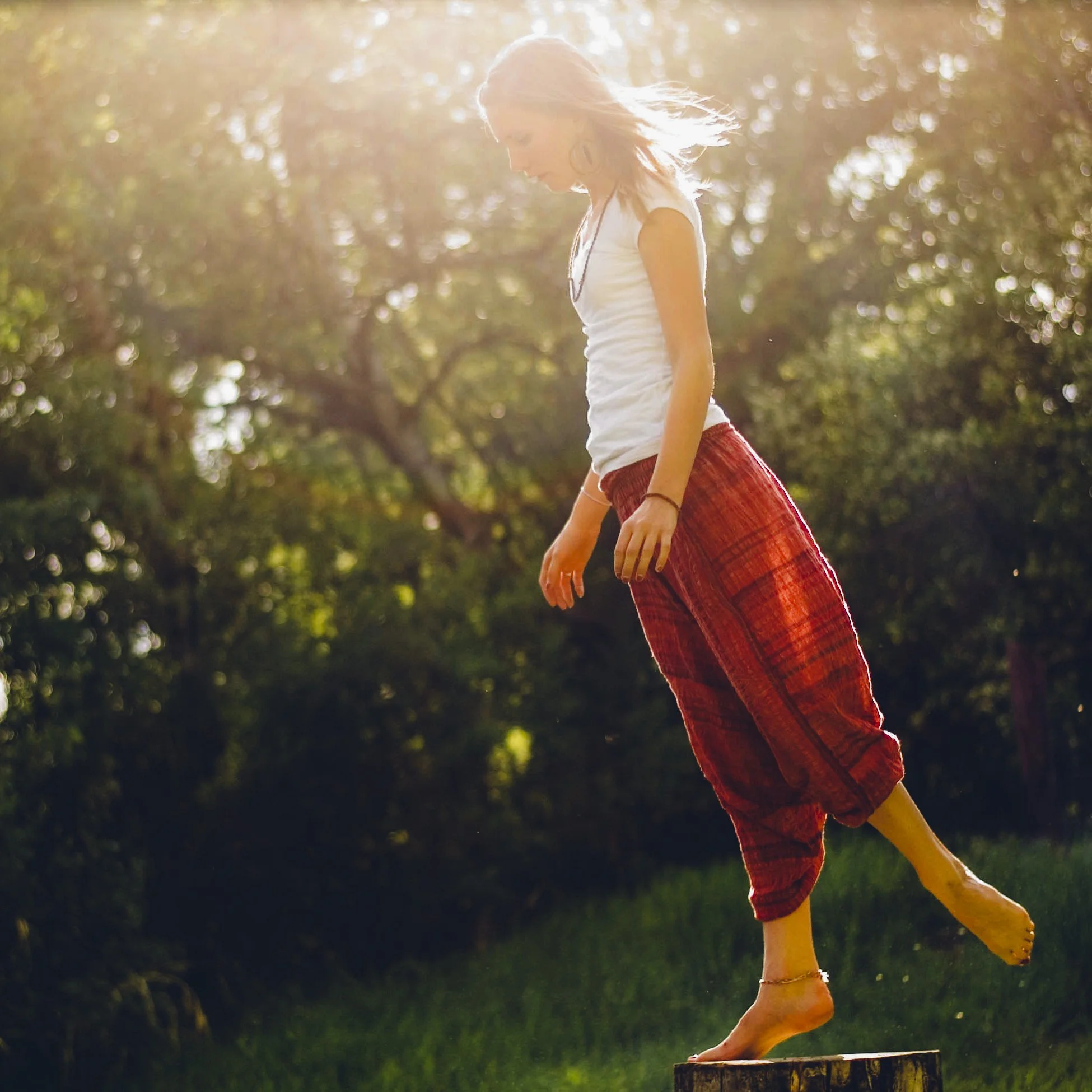 Woman balancing on one foot in sunshine
