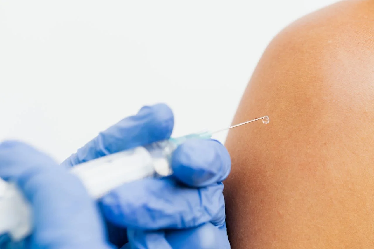 person getting a vitamin injection in their arm for wellness support