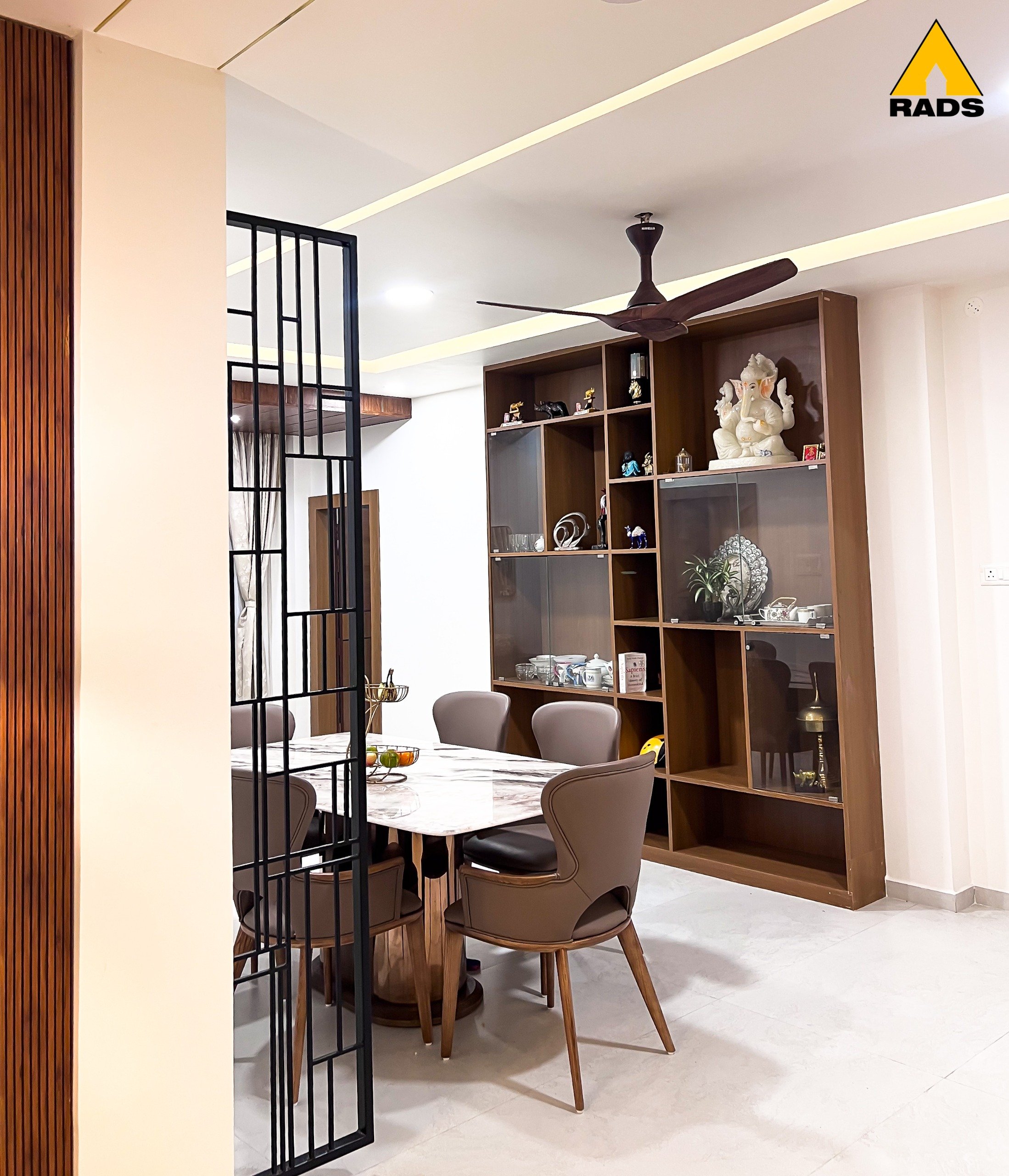Open layout dining space with integrated crockery unit and open shelves – interior project in Guwahati by RADS