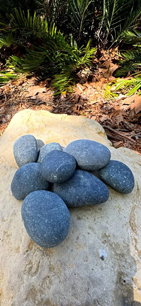 Black Tropical Beach Pebbles displayed on natural stone