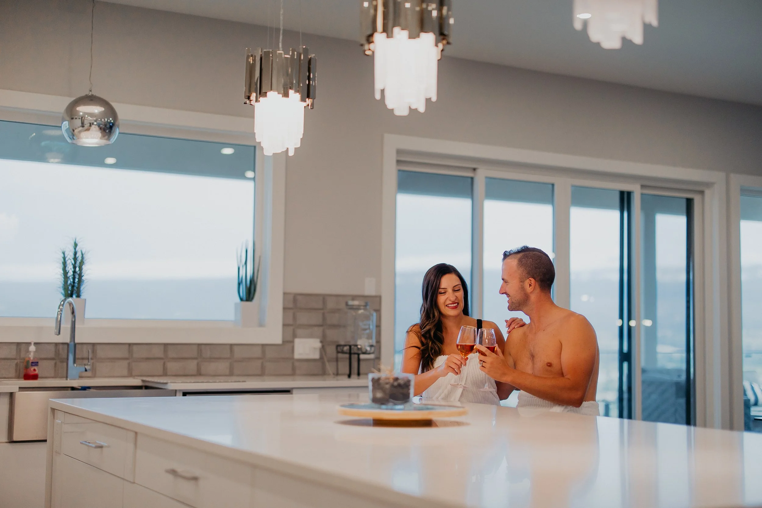 Couple doing wine toasting in The Thera Retreat kitchen hall