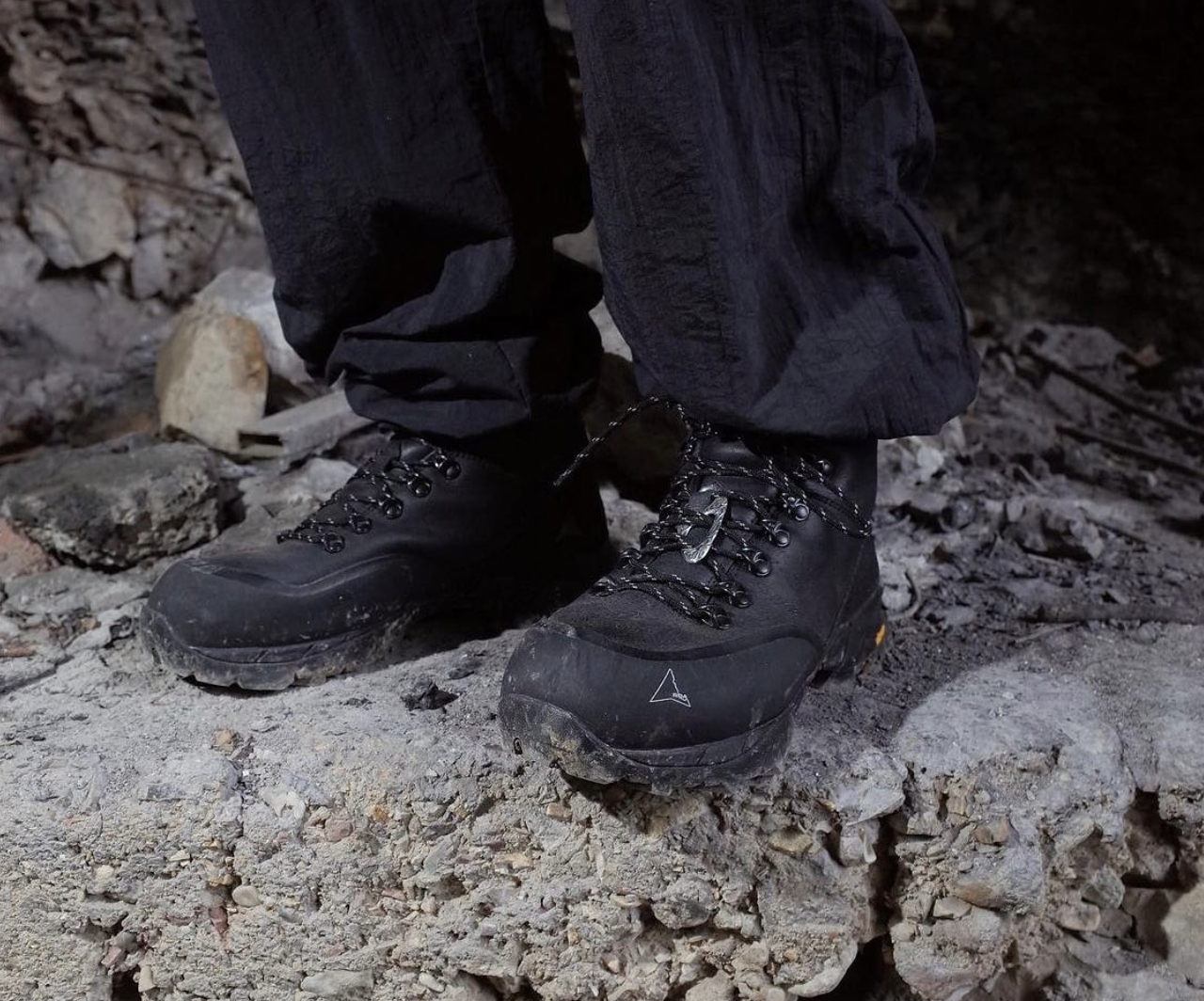 Chaussures de randonnée noires sur un sol rocheux.