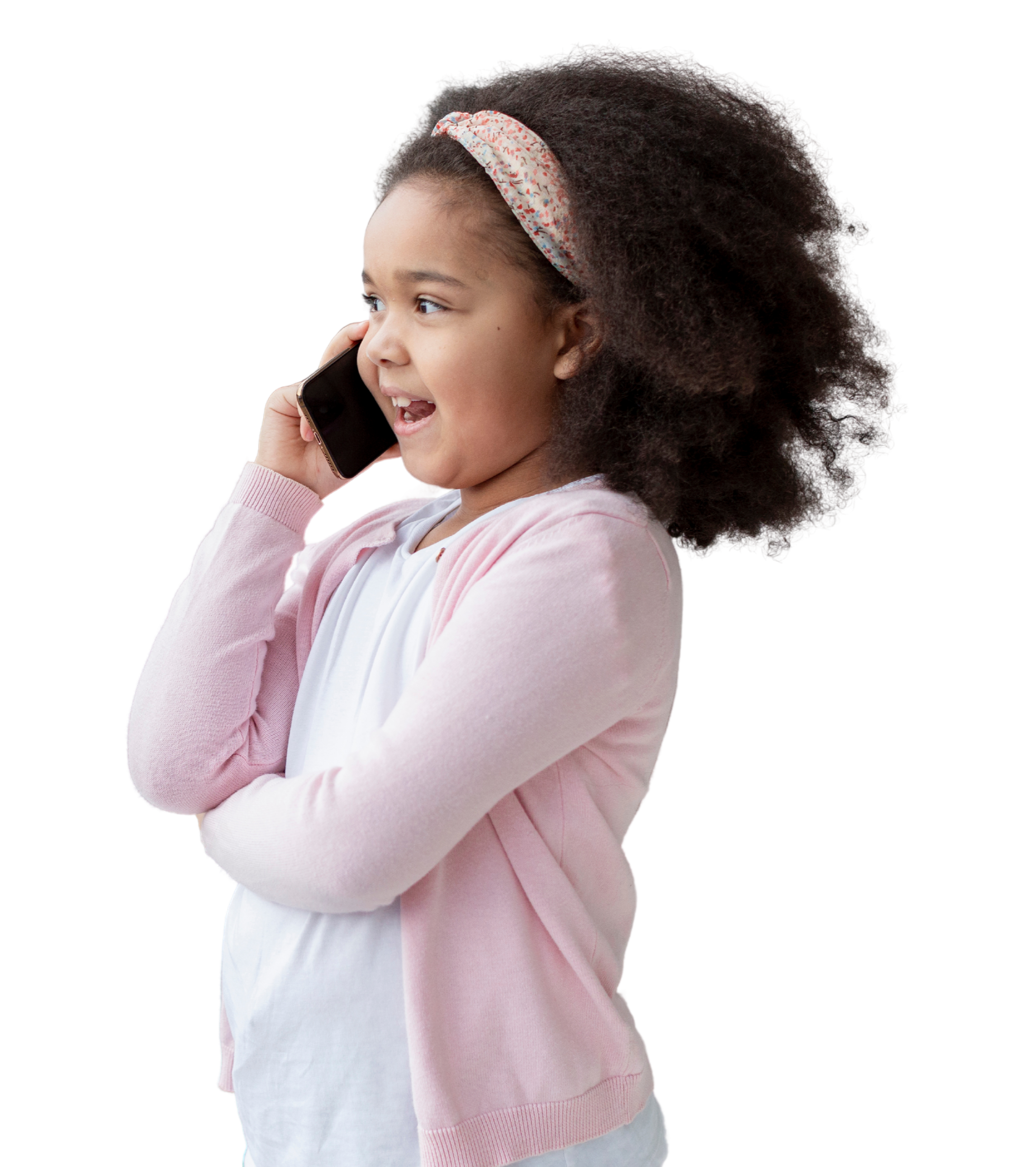 A young girl with curly hair wearing a floral headband, holding a smartphone to her ear, smiling and looking excited.