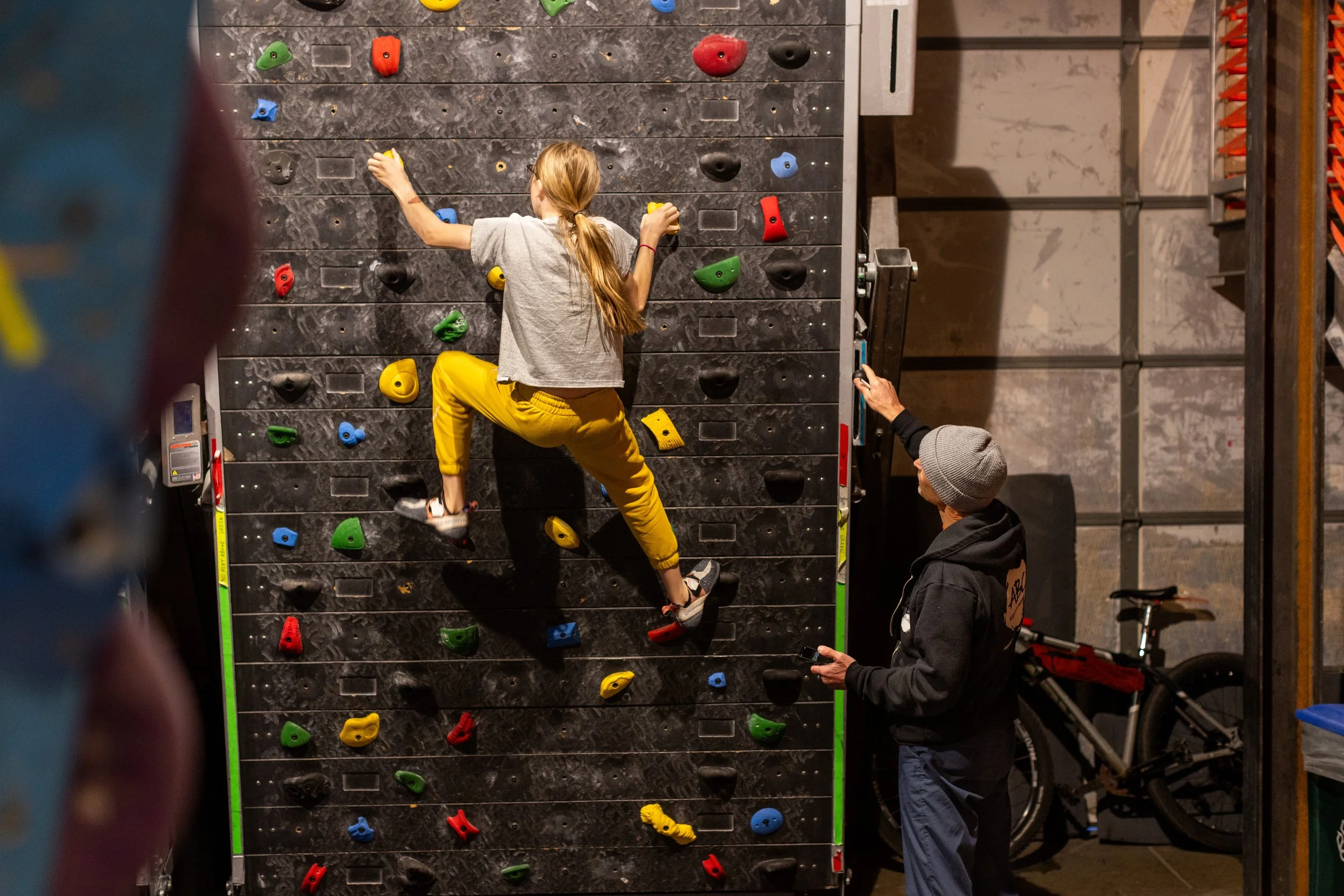 Team ABC Select U15+ climber training on a steep board as a coach watches at ABC Kids Climbing
