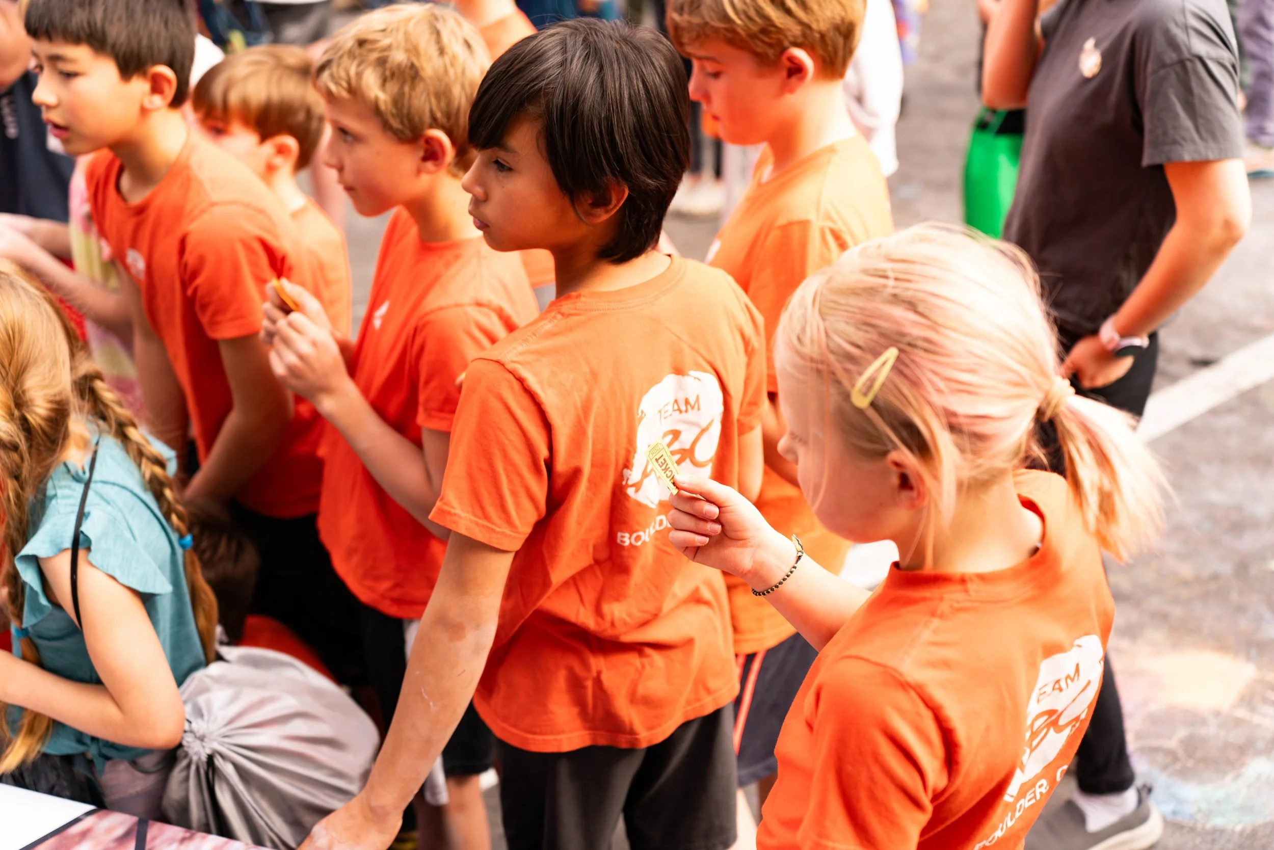 Kids in matching orange shirts at a custom group climbing event at ABC Kids Climbing in Boulder