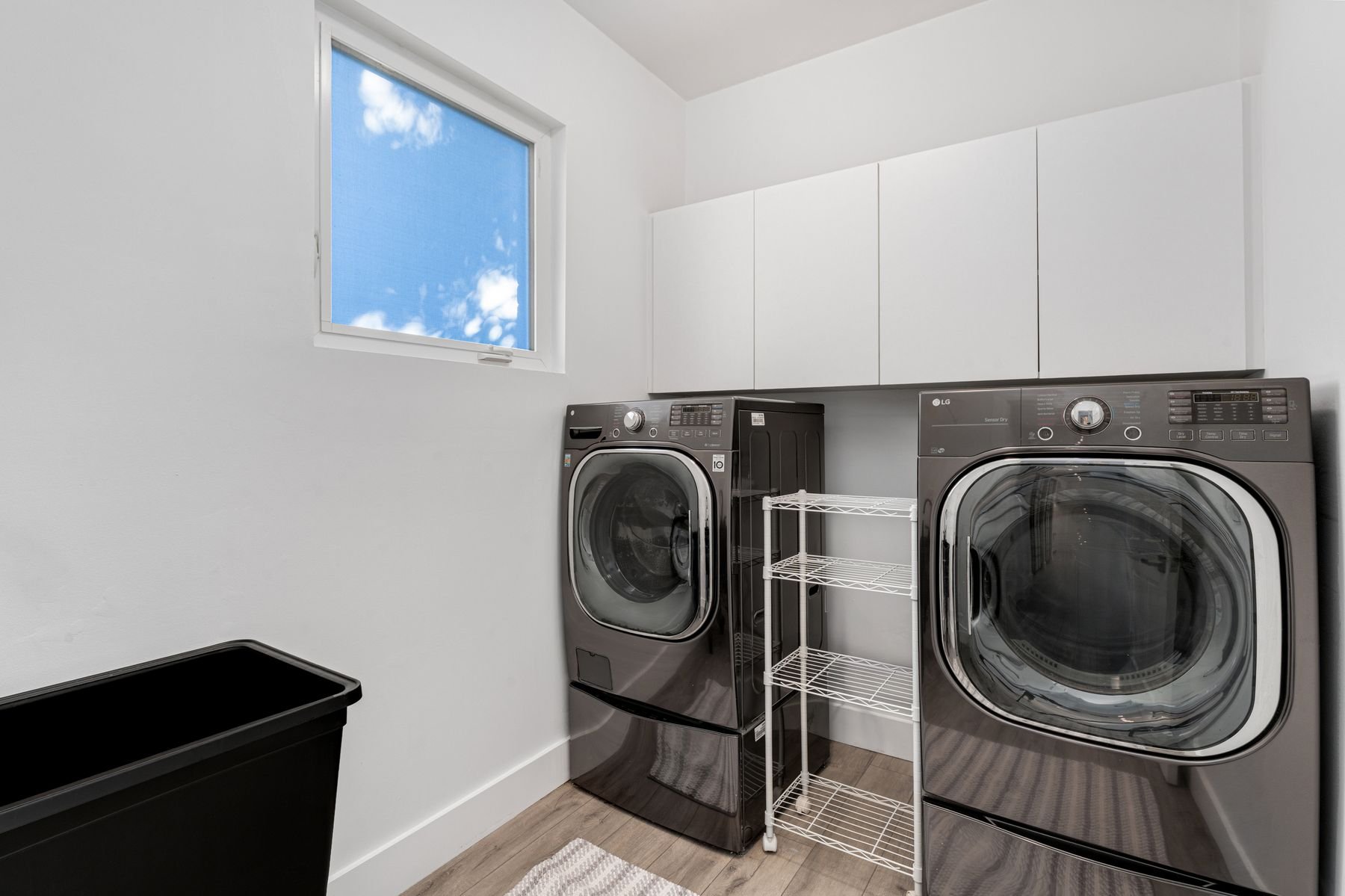 Laundry room with industrial size LG Washer and Dryer and storage; freestanding utility sink 