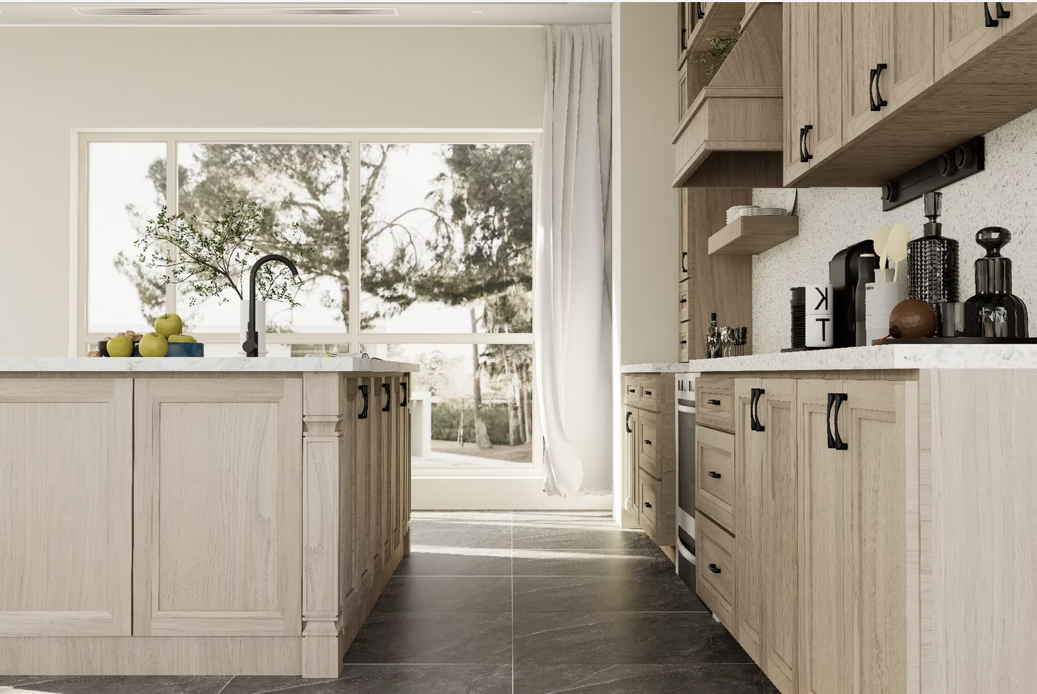 Modern kitchen with light wood cabinets, black hardware, white countertops, and a large window overlooking trees. On the counter are black and white canisters, a black coffee maker, and a small white vase. A bowl of apples and a small plant sit on the kitchen island.