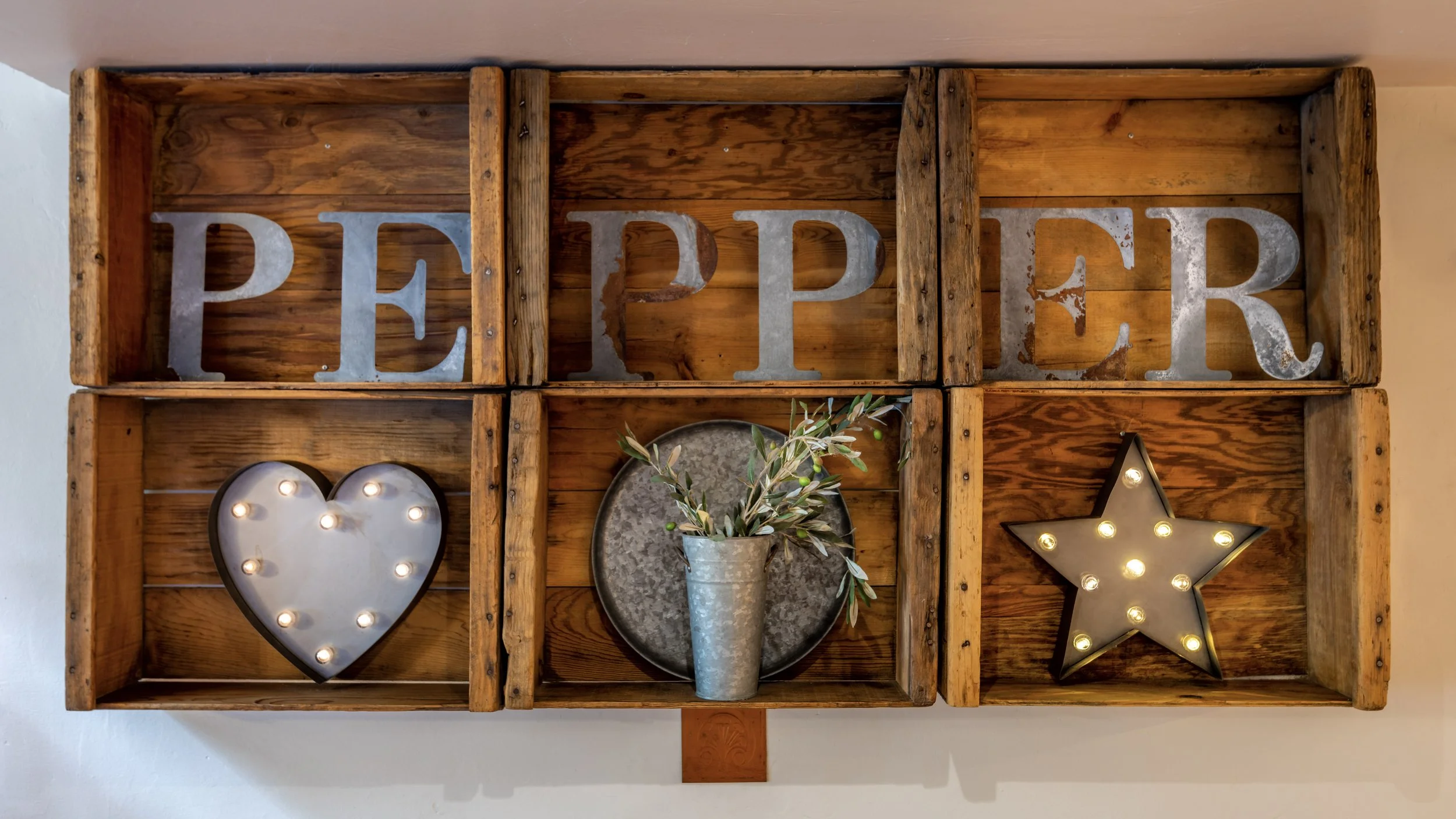 Decorative wooden wall display with the word PEPPER.