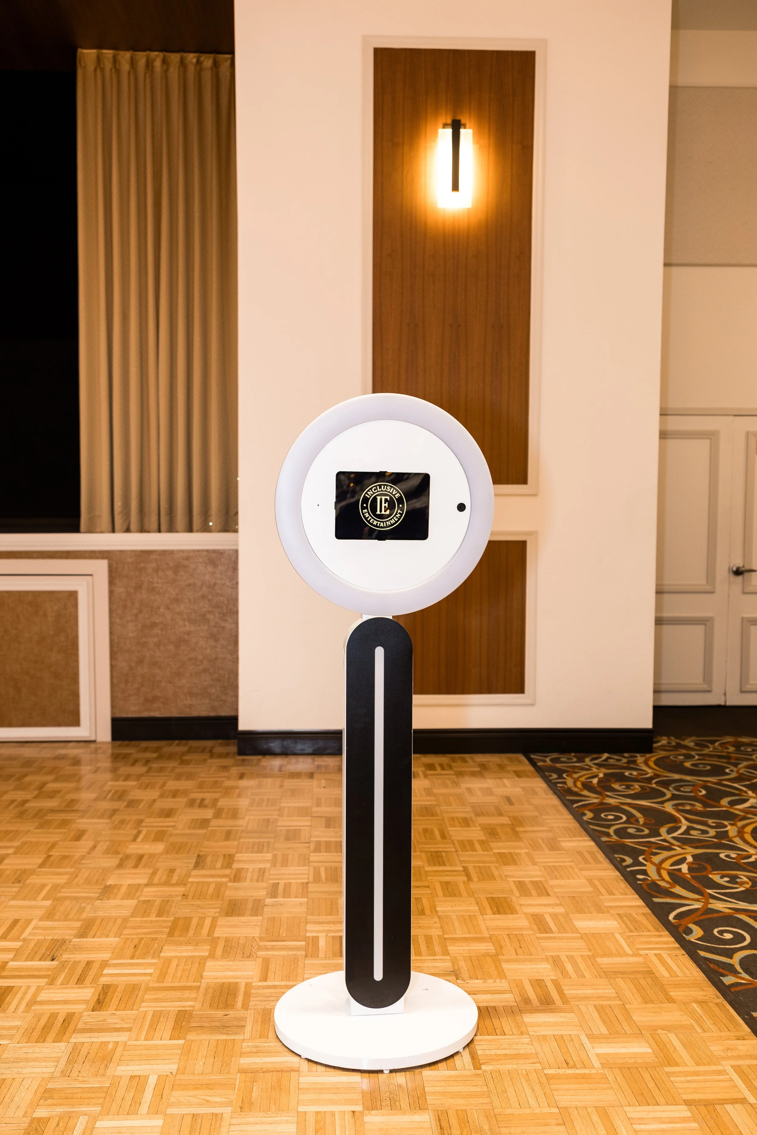 Selfie photo booth with LED lighting on a modern stand at indoor event venue, Inclusive Entertainment photo booth setup