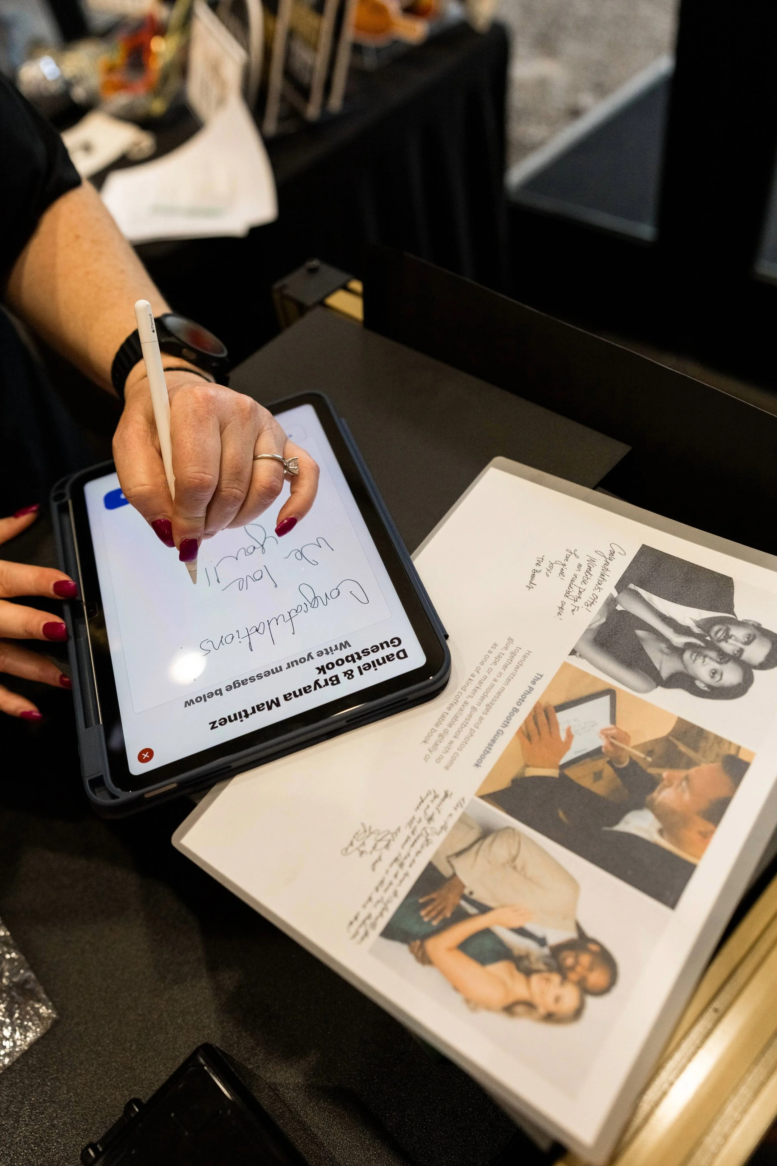 Guest signing digital guestbook on iPad with stylus, creating personalized messages paired with photo booth images by Patty’s Pix.