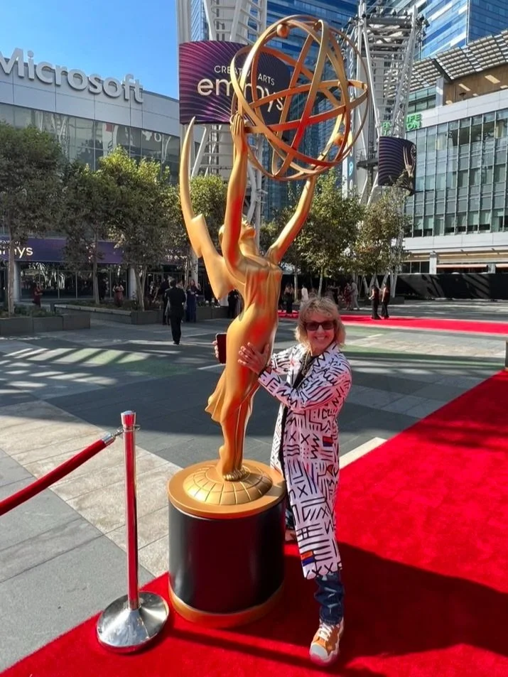 Gail L Russell standing next to Emmy Statue