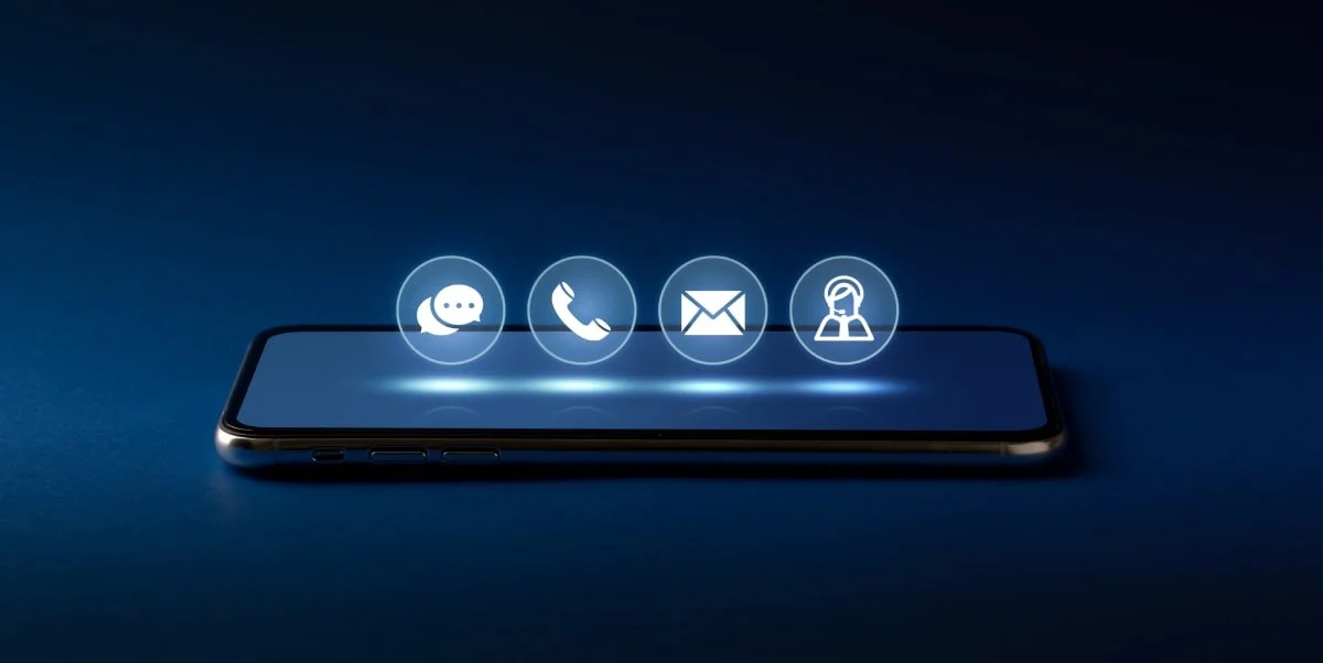 Smartphone with four icons above it representing messaging, phone call, email, and customer support.