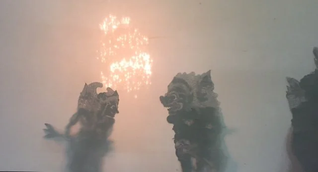 Three traditional Chinese dragon sculptures with fireworks in the sky above.