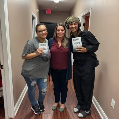 Danita Cummins with two readers holding copies of Promise Over Purpose